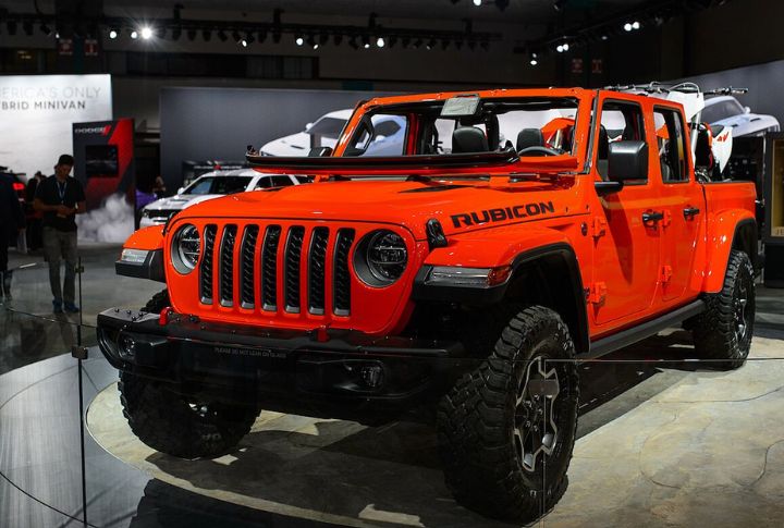 A red Jeep Wrangler Rubicon parked on a showroom floor