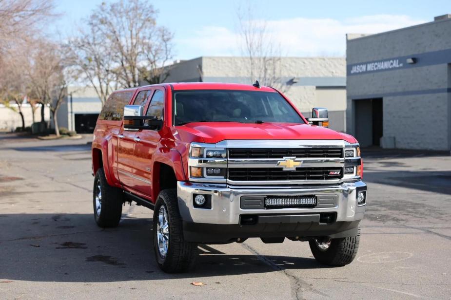 A red 2016 Chevrolet Silverado 2500 Duramax diesel parked in right front angle view