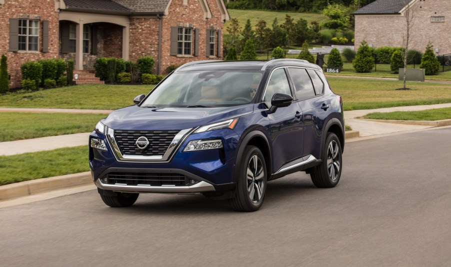 A blue 2021 Nissan Rogue photographed on a residential road