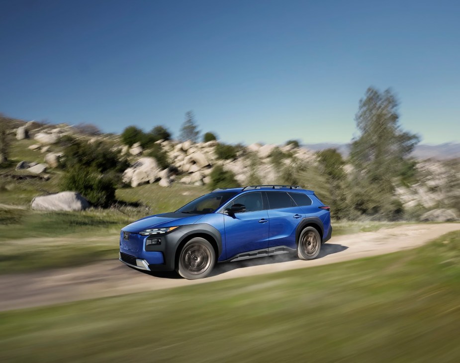 Blue Subaru Trailseeker wagon racing along a dirt road.
