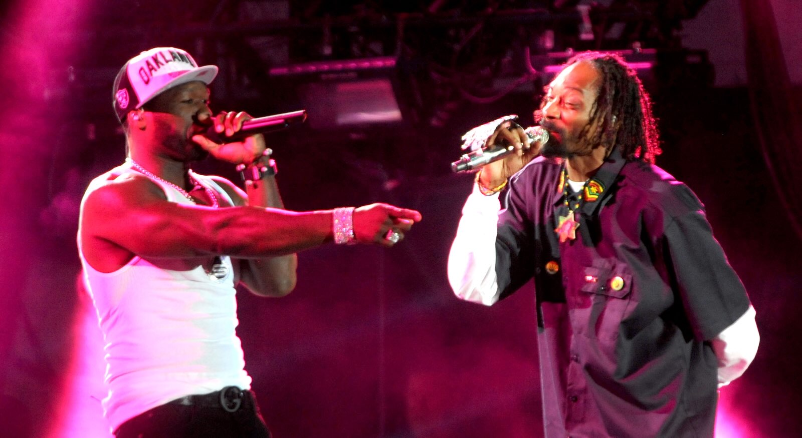 50 Cent and Snoop Dogg rap together on stage at a music festival.