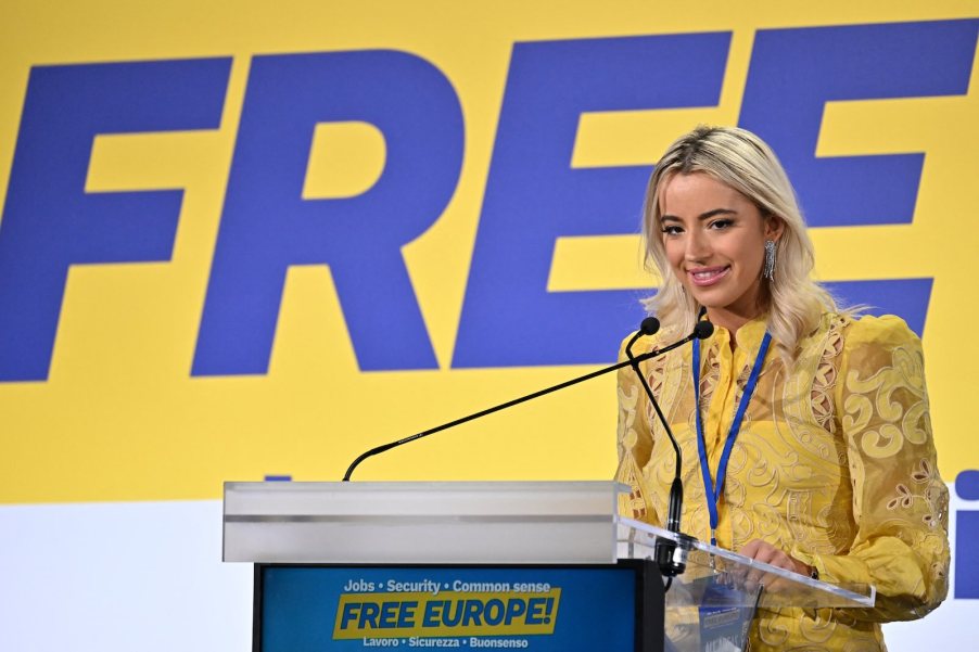 Ashley St. Clair, mother of Elon Musk's latest child, gives speech in Italy, standing behind a podium