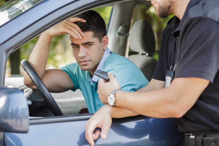 Car driver looks at his breathalyzer test results during a DUI traffic stop.