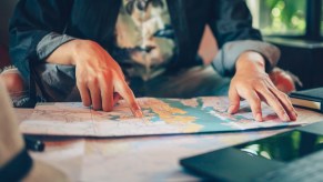Exchange student pointing at a map, planning his 6,800 mile roadtrip to school