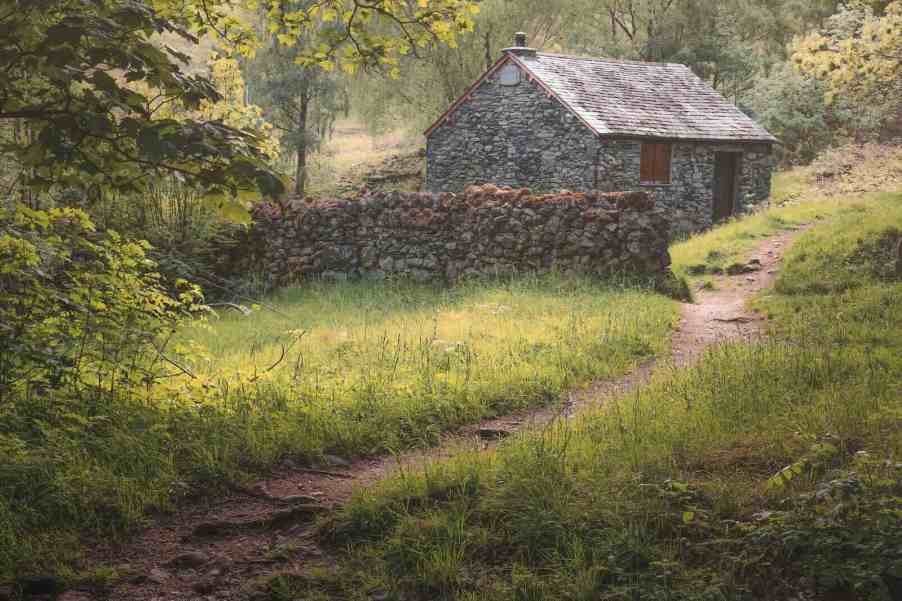 Scottish stone cottage in a field.