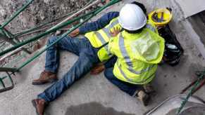Construction worker attends to injured man after Lamborghini crash.