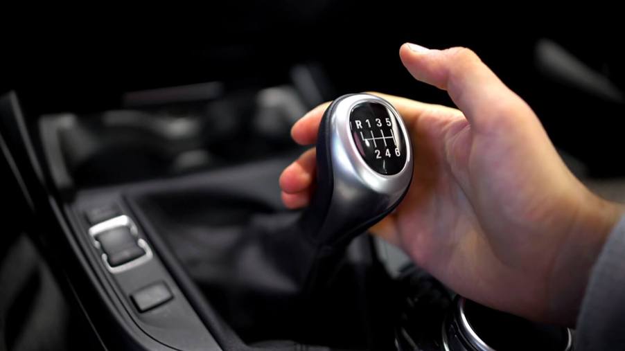 A person grabs for the gear shift as they learn how to drive a manual car.