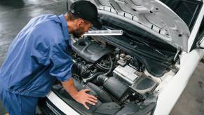 Mechanic examining a broken car that's making mysterious sounds.