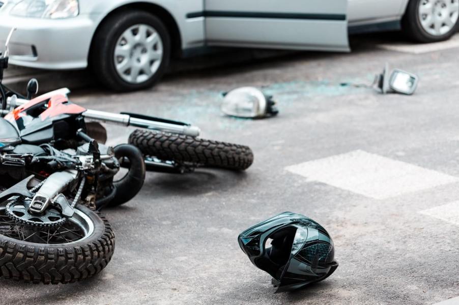 A helmet and wreckage on the ground after a hit-and-run incident with a motorcycle.