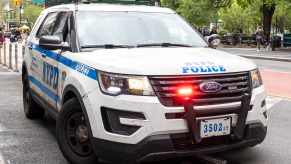 NYPD Officers in a parked Ford interceptor police cruiser on New York City streets