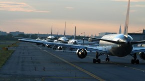 A row of jet liners delayed on the tarmac of a major airport.