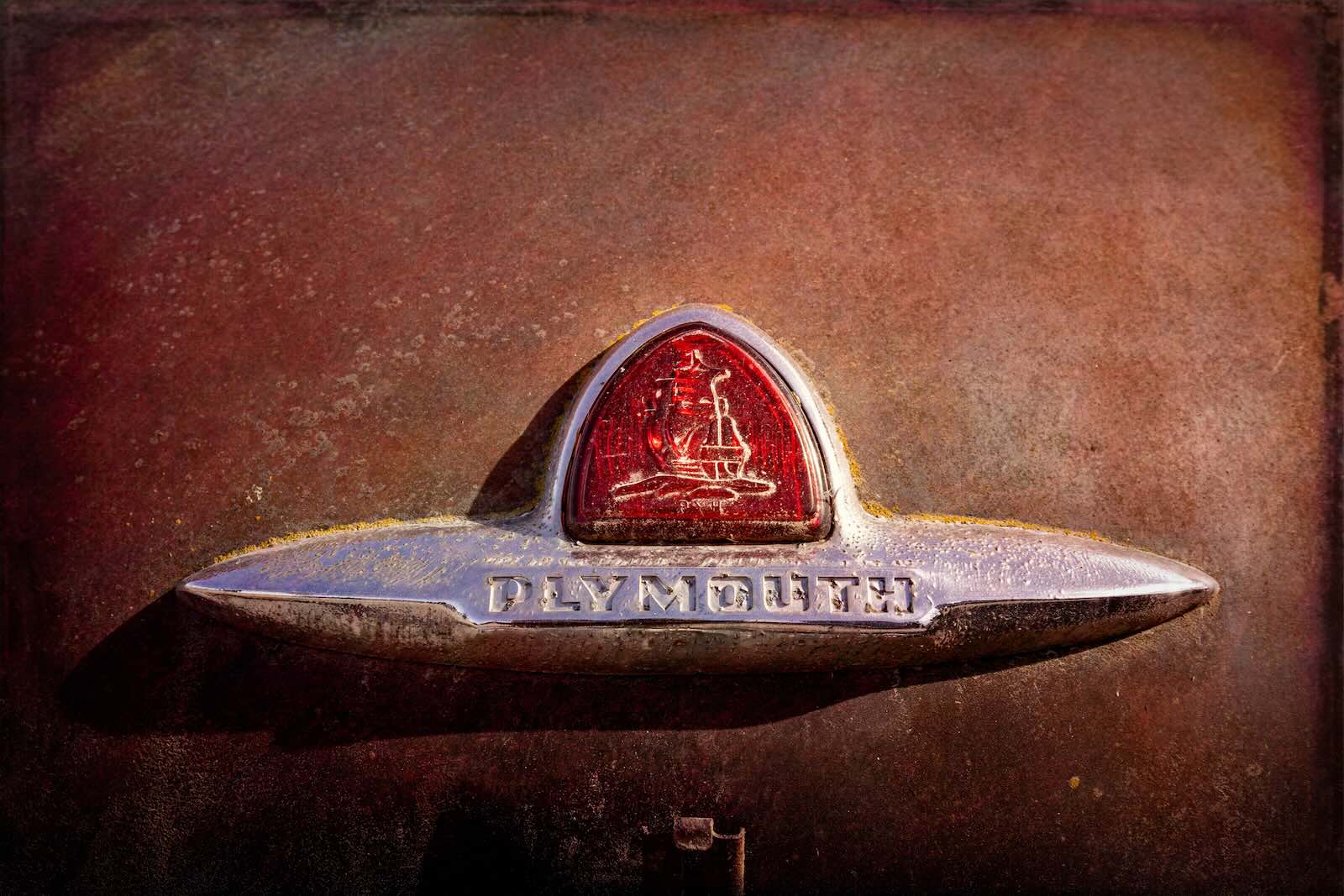 Plymouth badge on a classic muscle car by Chrysler corporation
