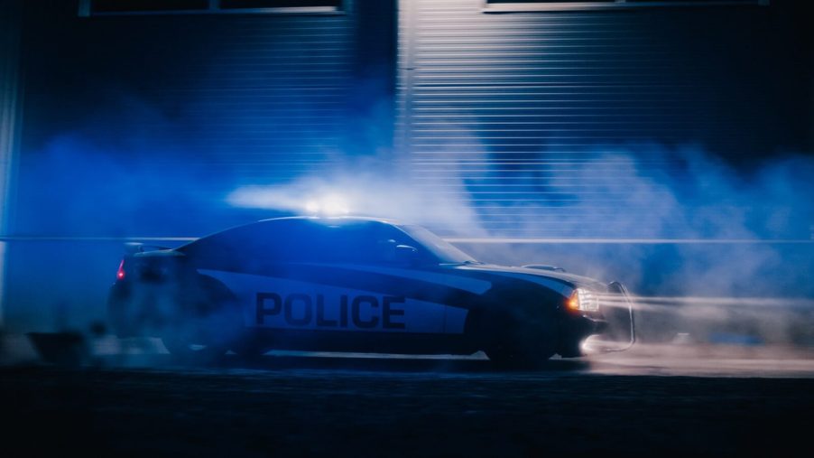A police Dodge Charger spins after another vehicle PIT maneuvers it.