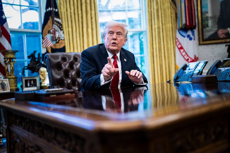 President Donald Trump sitting in the Oval Office of the White House discussing tariffs with reporters