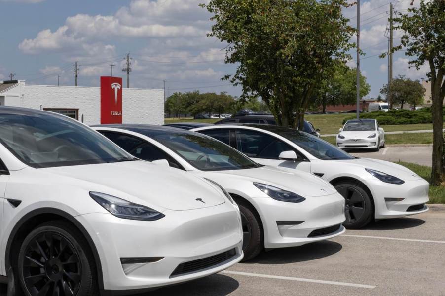 A row of Tesla Model 3 EVs at a Tesla dealer.