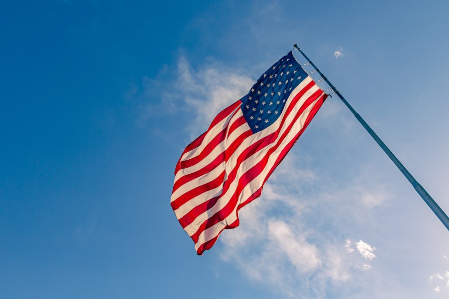 The American flag on a long pole, blue sky visible in the background.