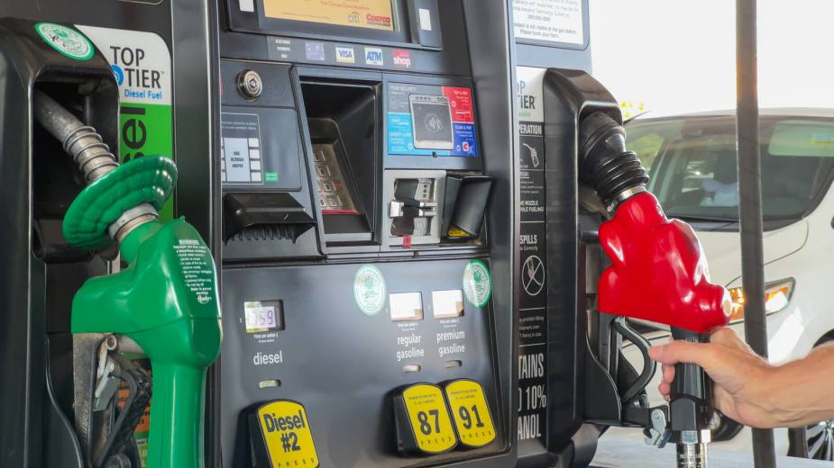 Hand holding gas pump with close view of the fuel pump options