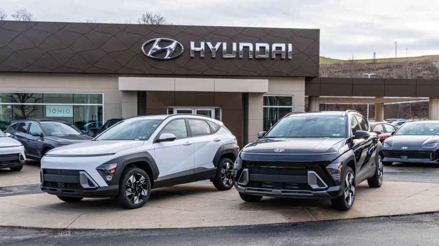 Two Hyundai Kona cars sitting in front of a Hyundai dealership