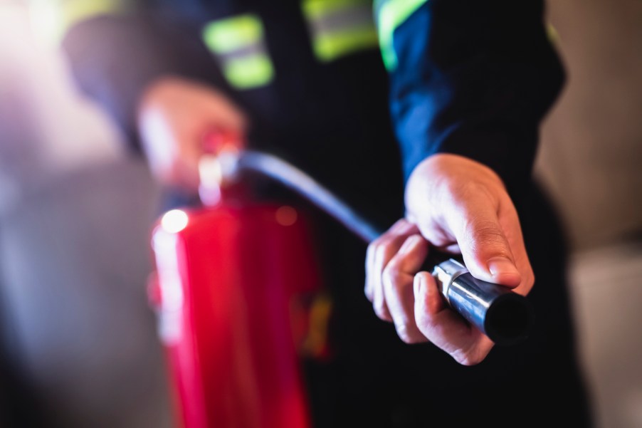A firefighter using a fire extinguisher