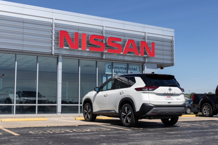 A Nissan dealership with SUV parked outside