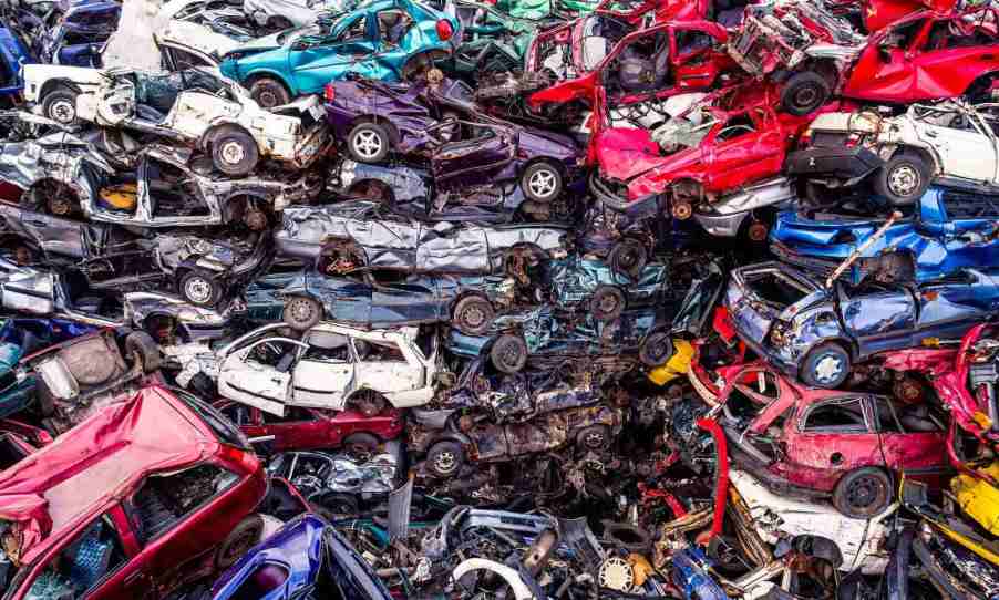 A pile of cars in a junkyard