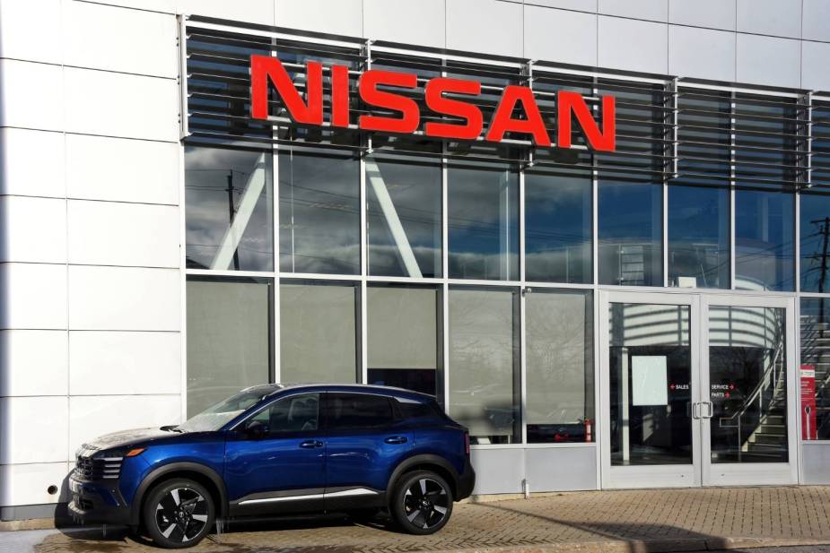 A Nissan Rogue parked in front of a Nissan dealership
