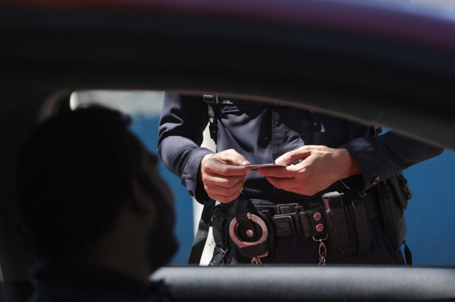 Police officer checks driver's license and vehicle registration during a traffic stop in close view