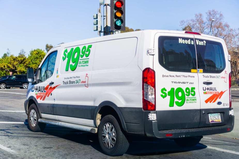 A U-Haul Ford Transit van at a stop light in left rear view