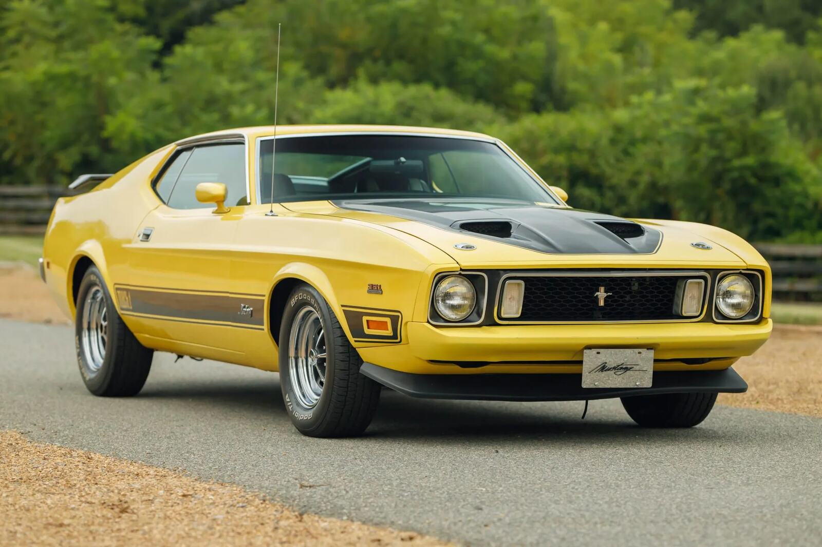 A yellow 1973 Ford Mustang parked in right front angle view