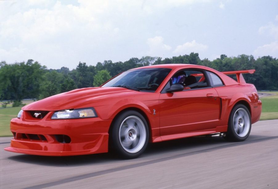 A bright red, one-of-300 Ford Mustang SVT Cobra R drives on a strip.