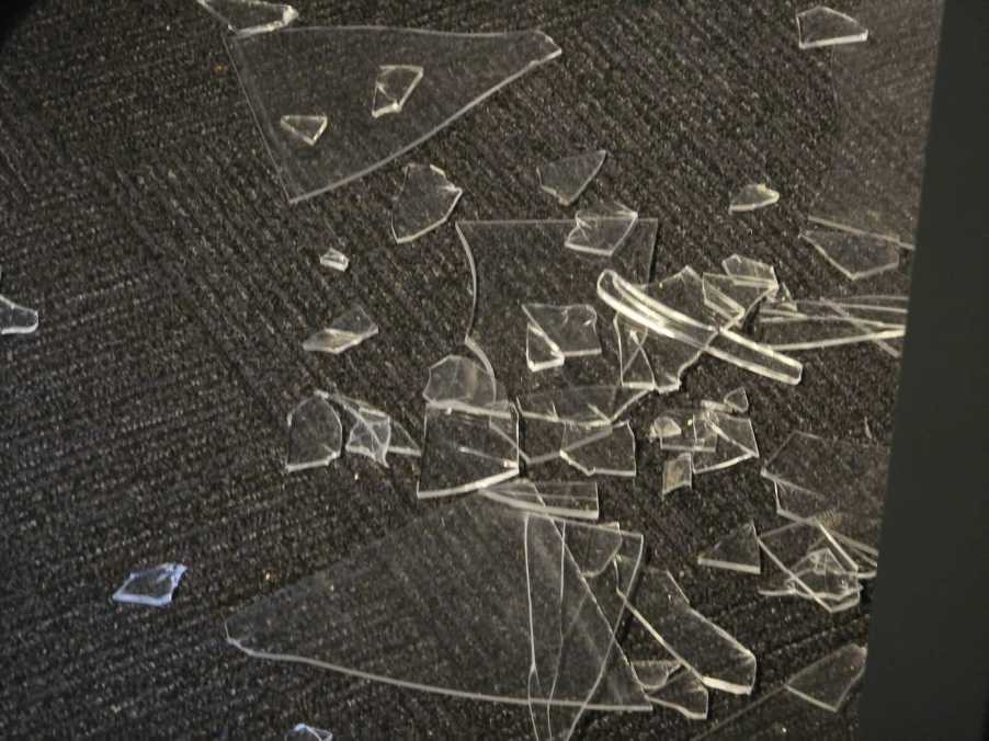 Broken glass on the floor of a Cadillac dealership after falling cars smashed a window