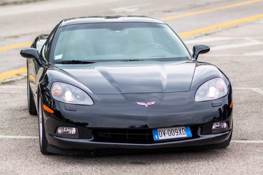 Black Chevrolet Corvette taking up four spots in a parking lot.