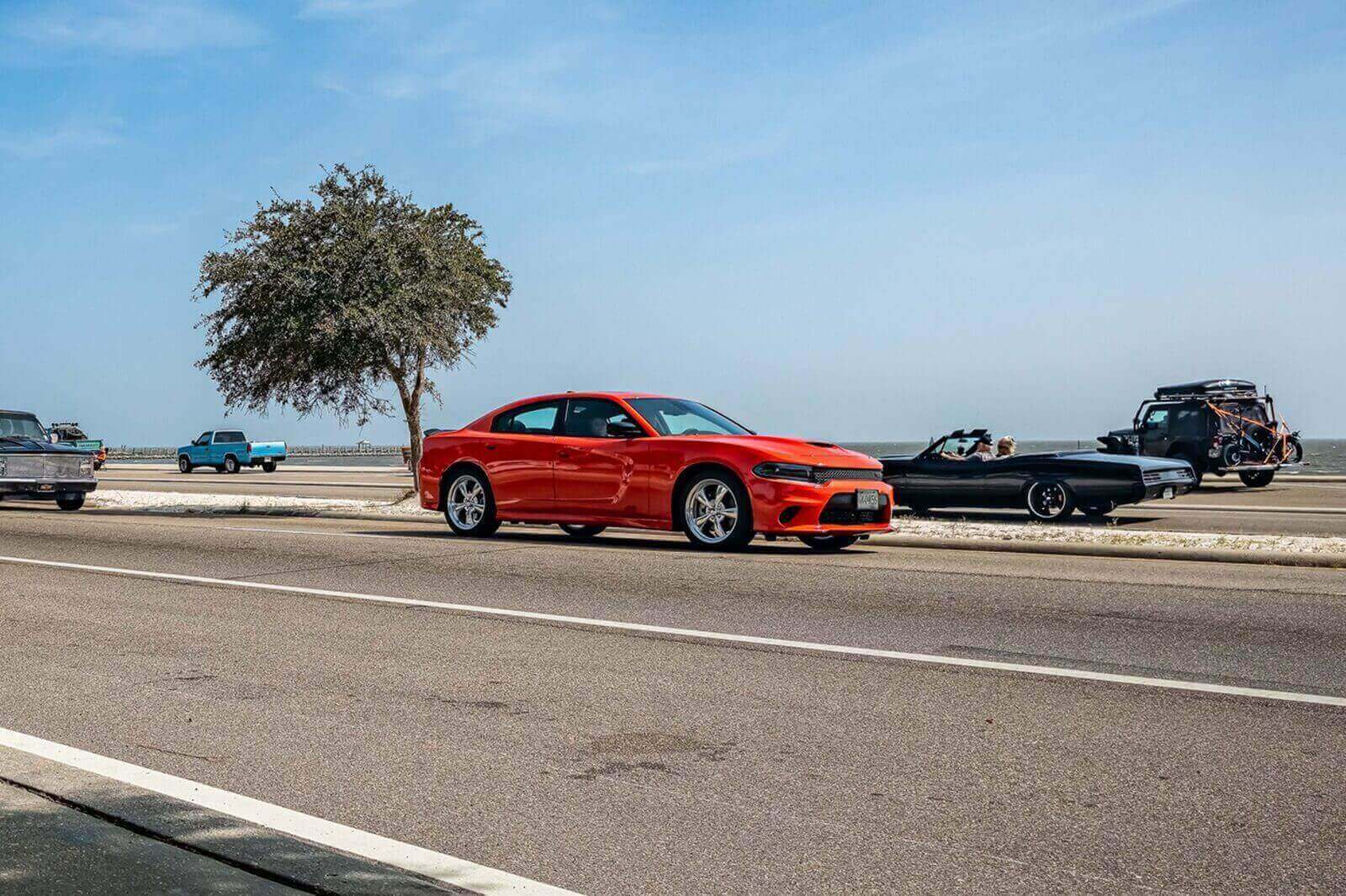 A red Dodge Charger goes driving by.