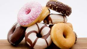 Stack of various donuts on a countertop, in front of a white background