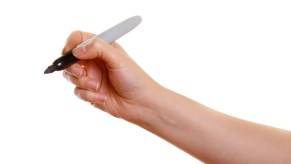 Hand using a sharpie marker to draw.