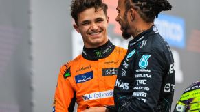 Formula 1 (F1) drivers Lando Norris and Lewis Hamilton laugh together.