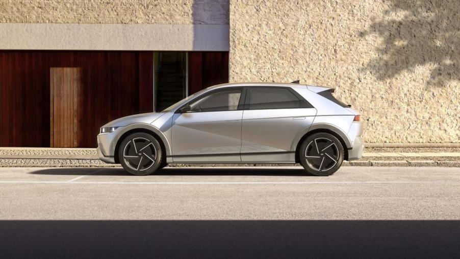 A Hyundai IONIQ 5, one of the top rivals for the Tesla Model Y, is parked alongside a large sandy building.