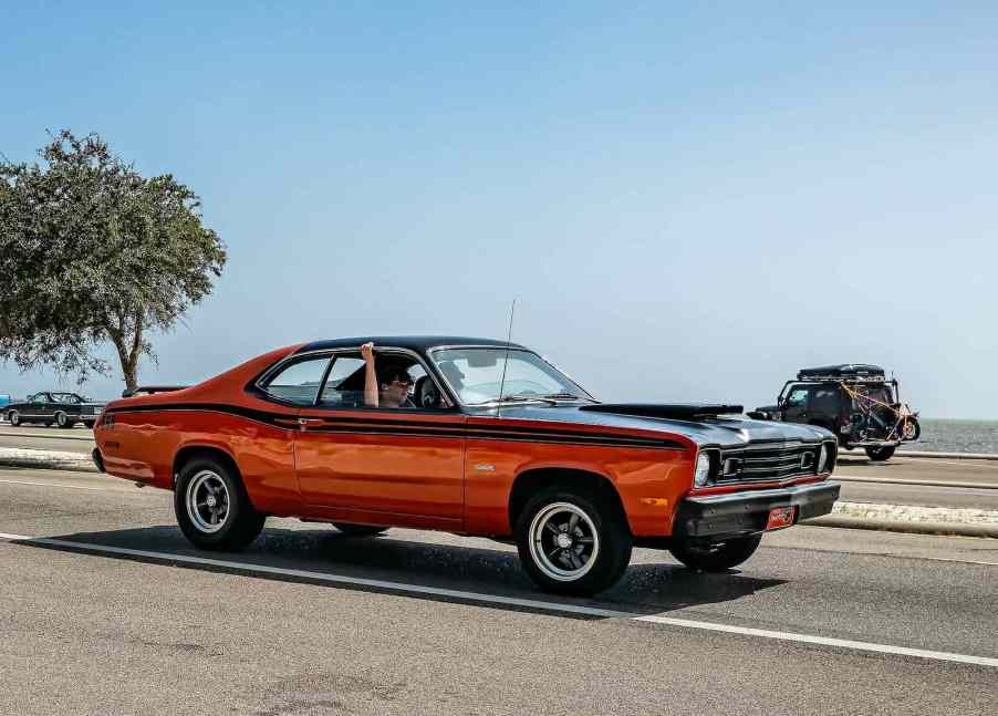 Red Plymouth Duster muscle car on the highway.
