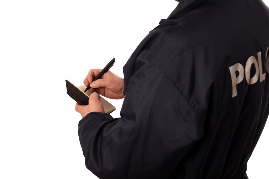 Police impersonator with a notebook during a fake traffic stop to steal a car.