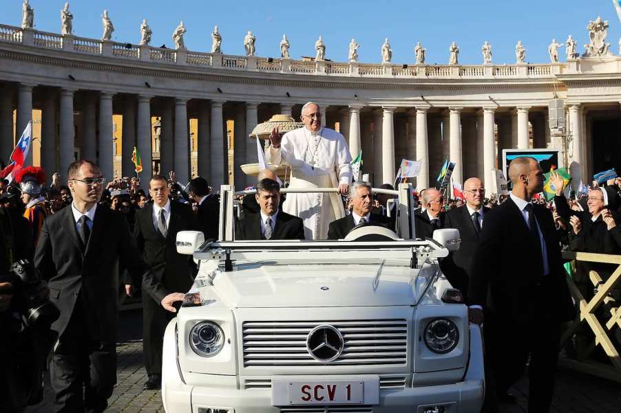The late Pope Francis parades through Vatican City in his Mercedes Popemobile car.
