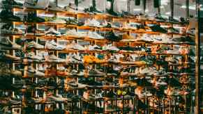 Shelves of Nike sneakers in front of a mirror in a store.