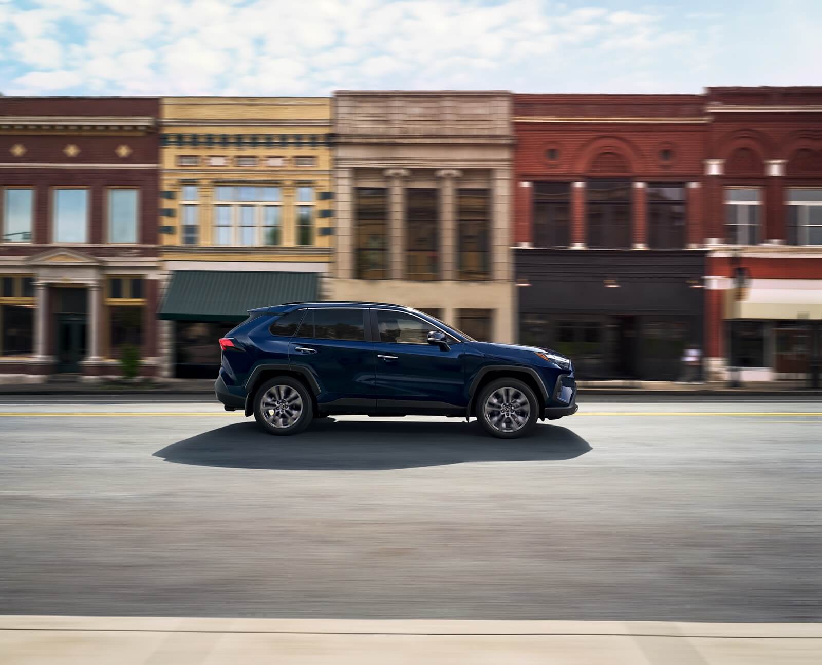 The 2025 Toyota RAV4, the best-selling vehicle in America, drives on a town street.
