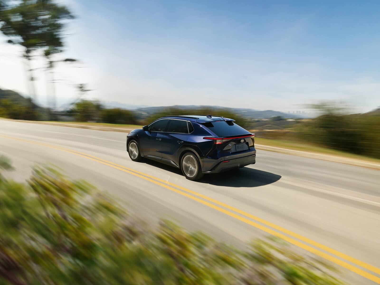 A dark blue Toyota bZ, the replacement for the bZ4X, hits the road.