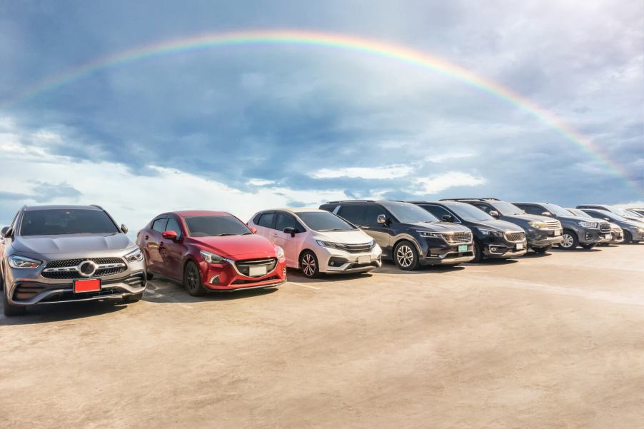 Cars parked under a rainbow in the sky
