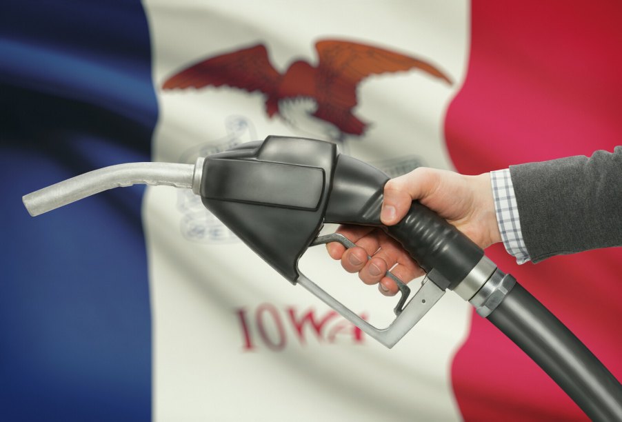 Fuel pump nozzle held in front of the Iowa state flag