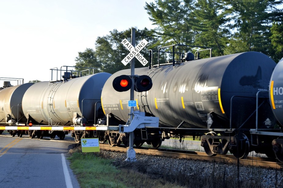 A train going down the tracks at a rail road crossing