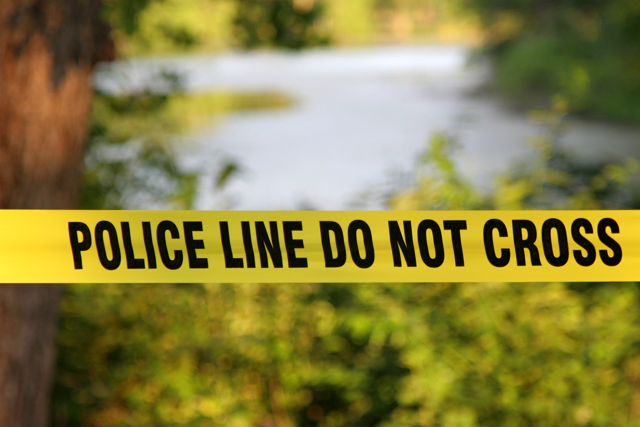 Police tape up by a river because a Jeep sank in the water