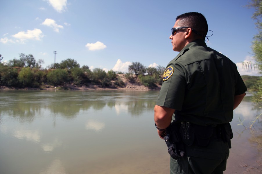 A border patrol agent looking at the river