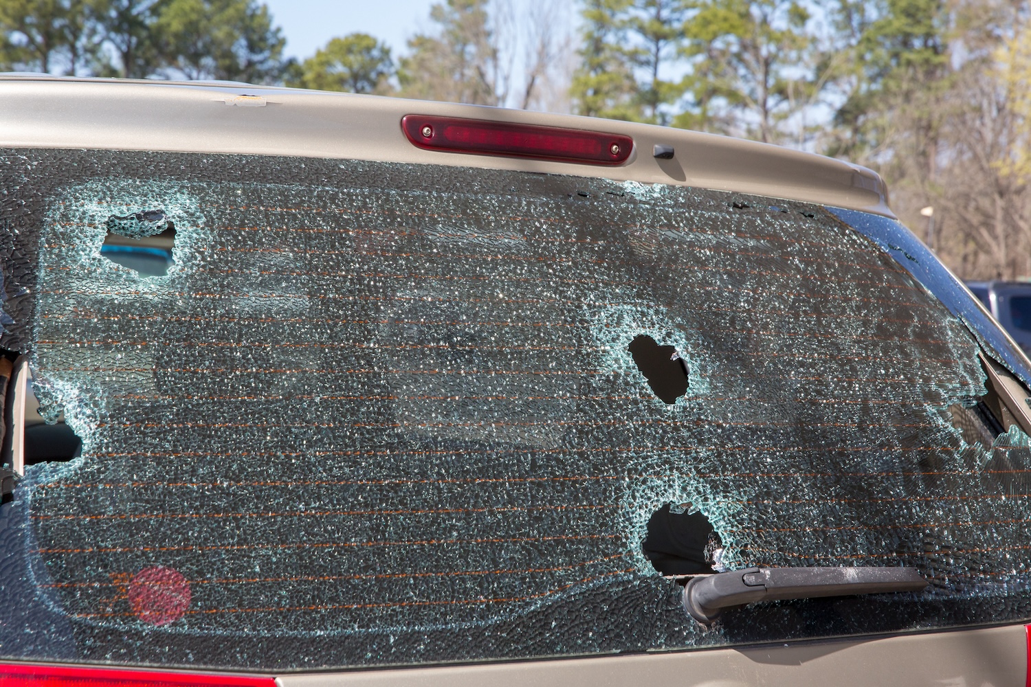 An SUV with bullet holes in the back
