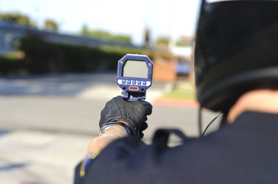 Police officer holding a speed radar looking to initiate a traffic stop